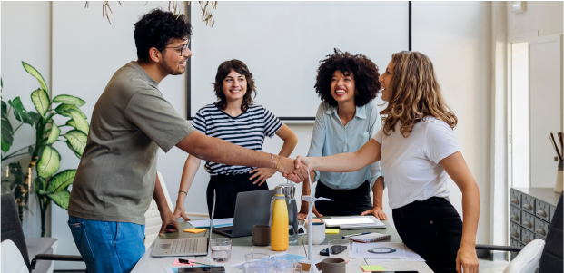 People shaking hands in a modern office meeting room.